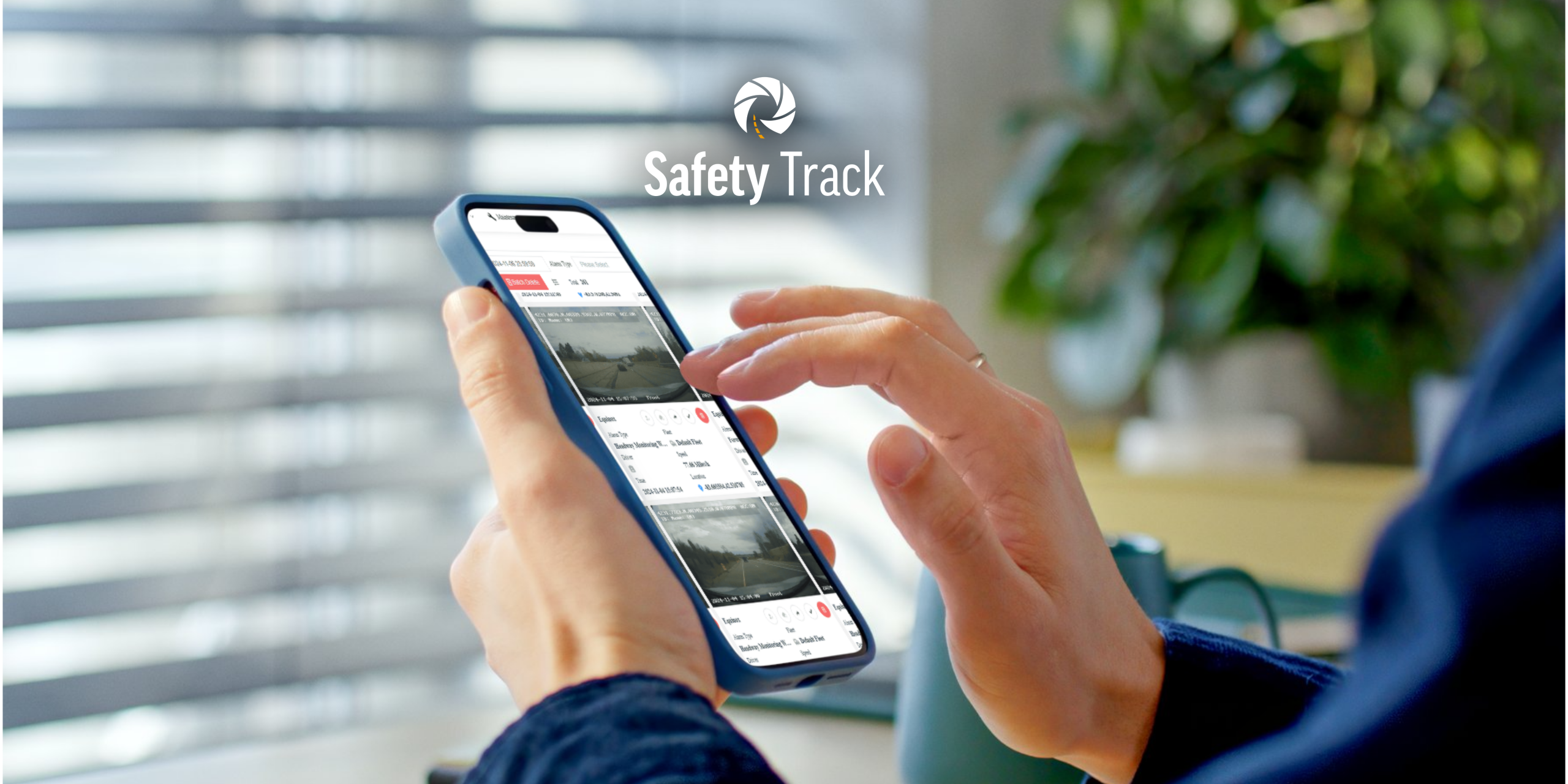 Person using smartphone to access Safety Track remote video monitoring for fleet security, with interface displaying vehicle footage and alerts.