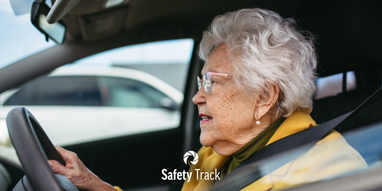 Older woman driving a car, emphasizing safe driving practices, with Safety Track logo visible, highlighting fleet management and driver safety.