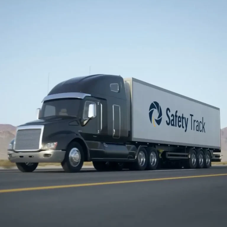 Black semi-truck with a large trailer featuring "Safety Track" logo, driving on a highway.
